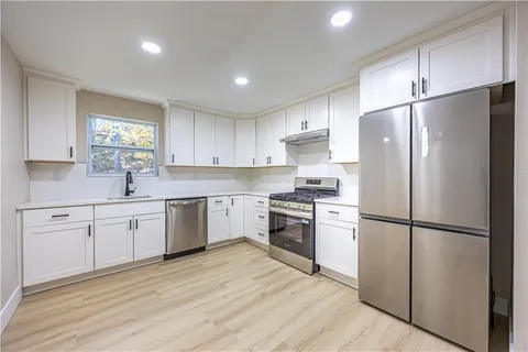 a kitchen with a refrigerator stove top oven and sink