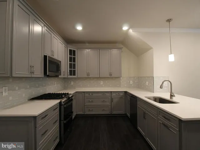 a kitchen that has a sink and a stove in it