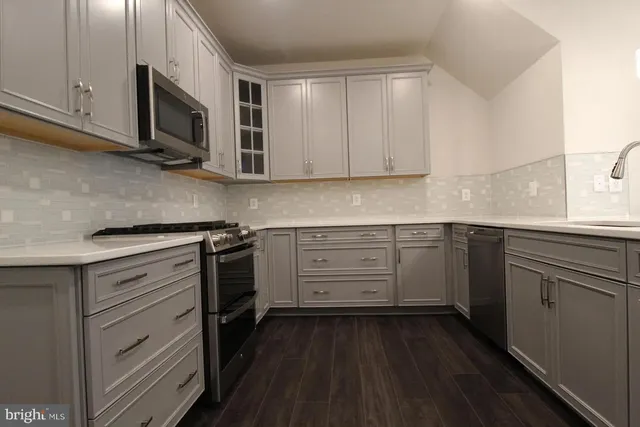 a kitchen with stainless steel appliances a stove microwave and cabinets