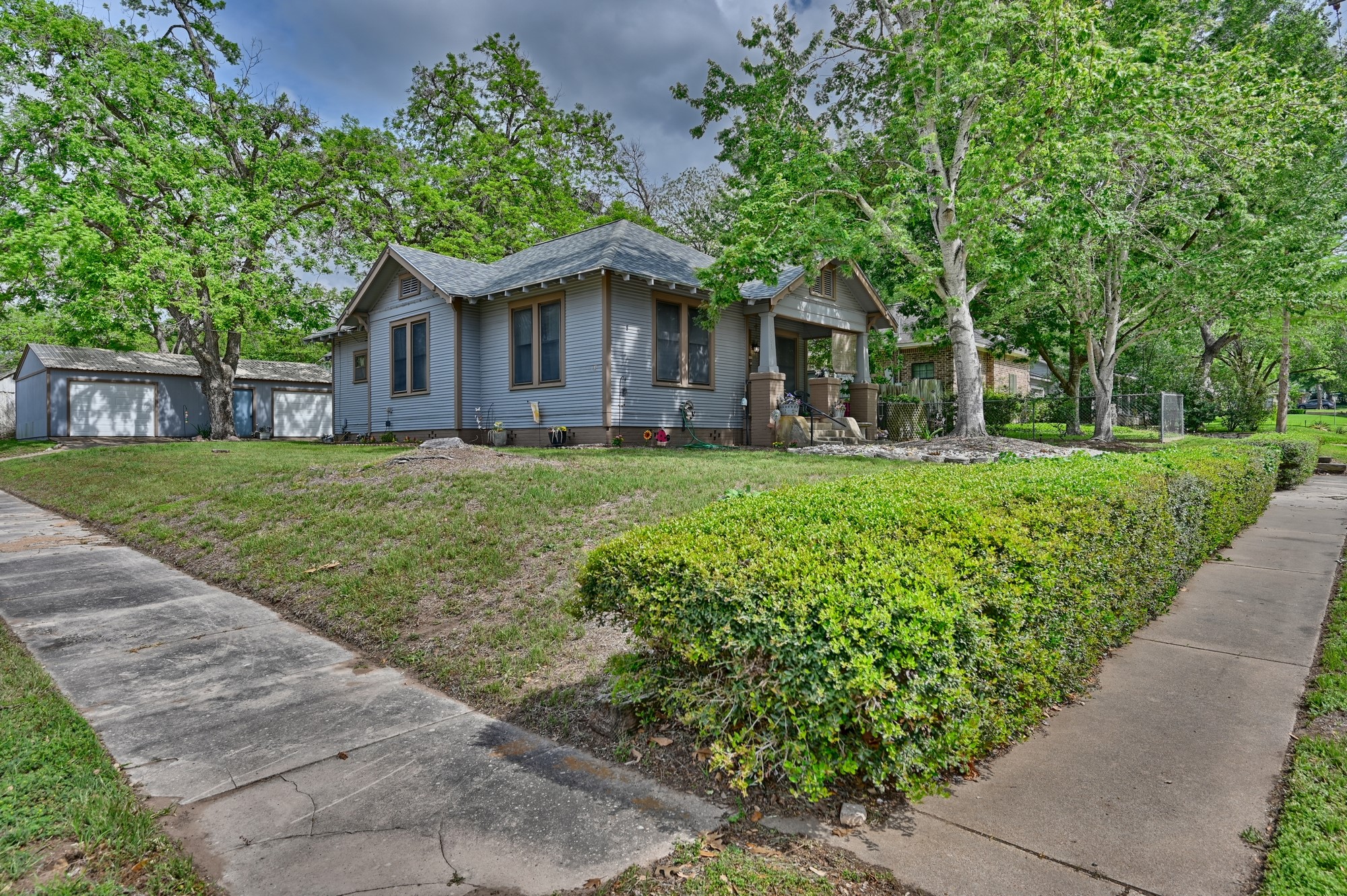 1501 South Austin Street Brenham, TX 77833 - Photo 32 of 36 a front view of a house with a garden and trees