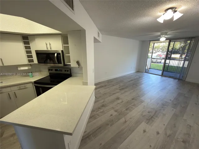a kitchen with a sink a microwave a stove and refrigerator
