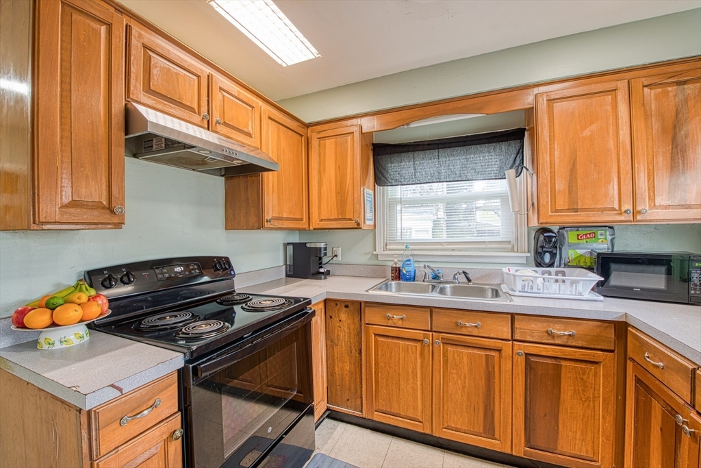 499 Maple Street Fall River, MA 02720 - Photo 7 of 21 a kitchen with stainless steel appliances granite countertop a sink stove and cabinets