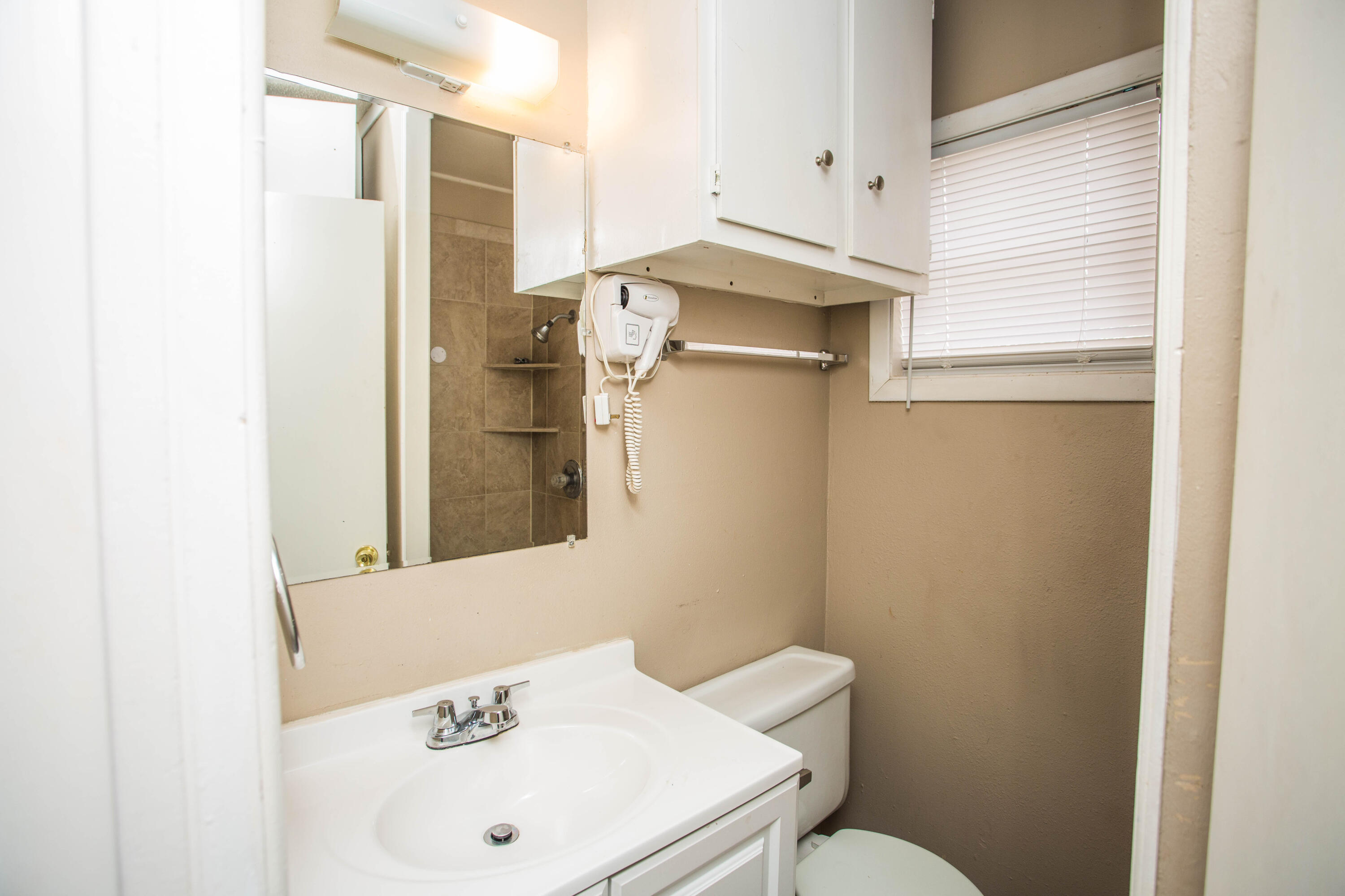 4309 42nd Street Lubbock, TX 79413 - Photo 12 of 25 a bathroom with a sink a toilet and shower curtain