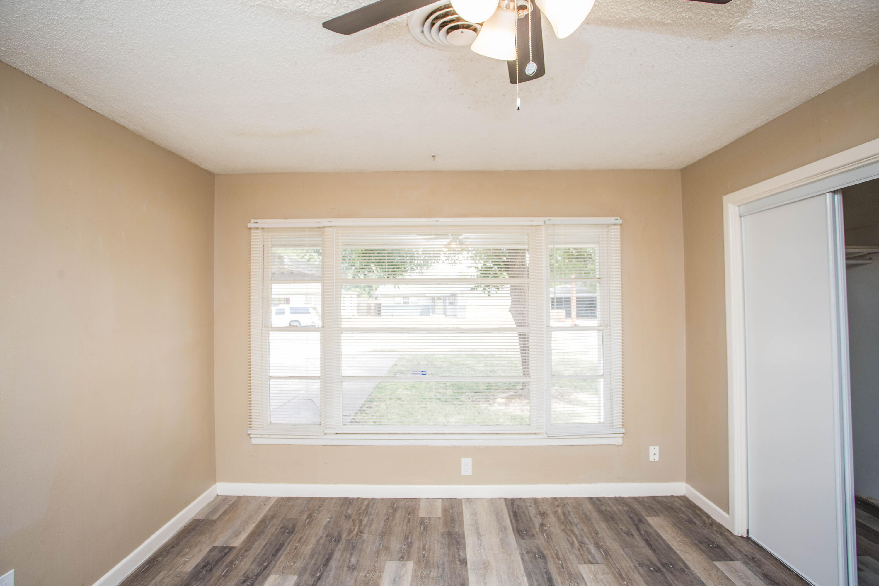 4309 42nd Street Lubbock, TX 79413 - Photo 14 of 25 an empty room with wooden floor and windows
