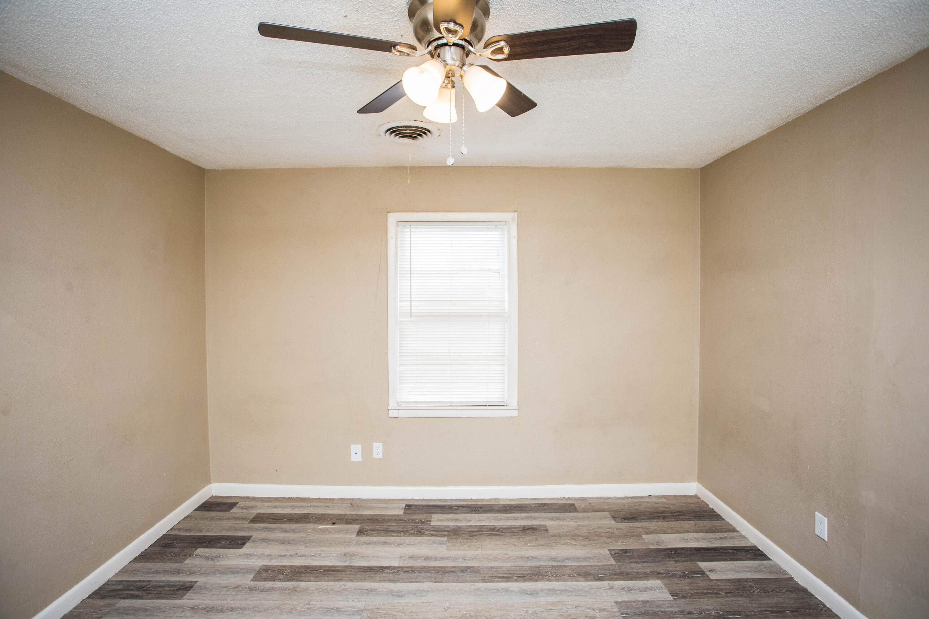 4309 42nd Street Lubbock, TX 79413 - Photo 21 of 25 a view of an empty room with wooden floor and a window