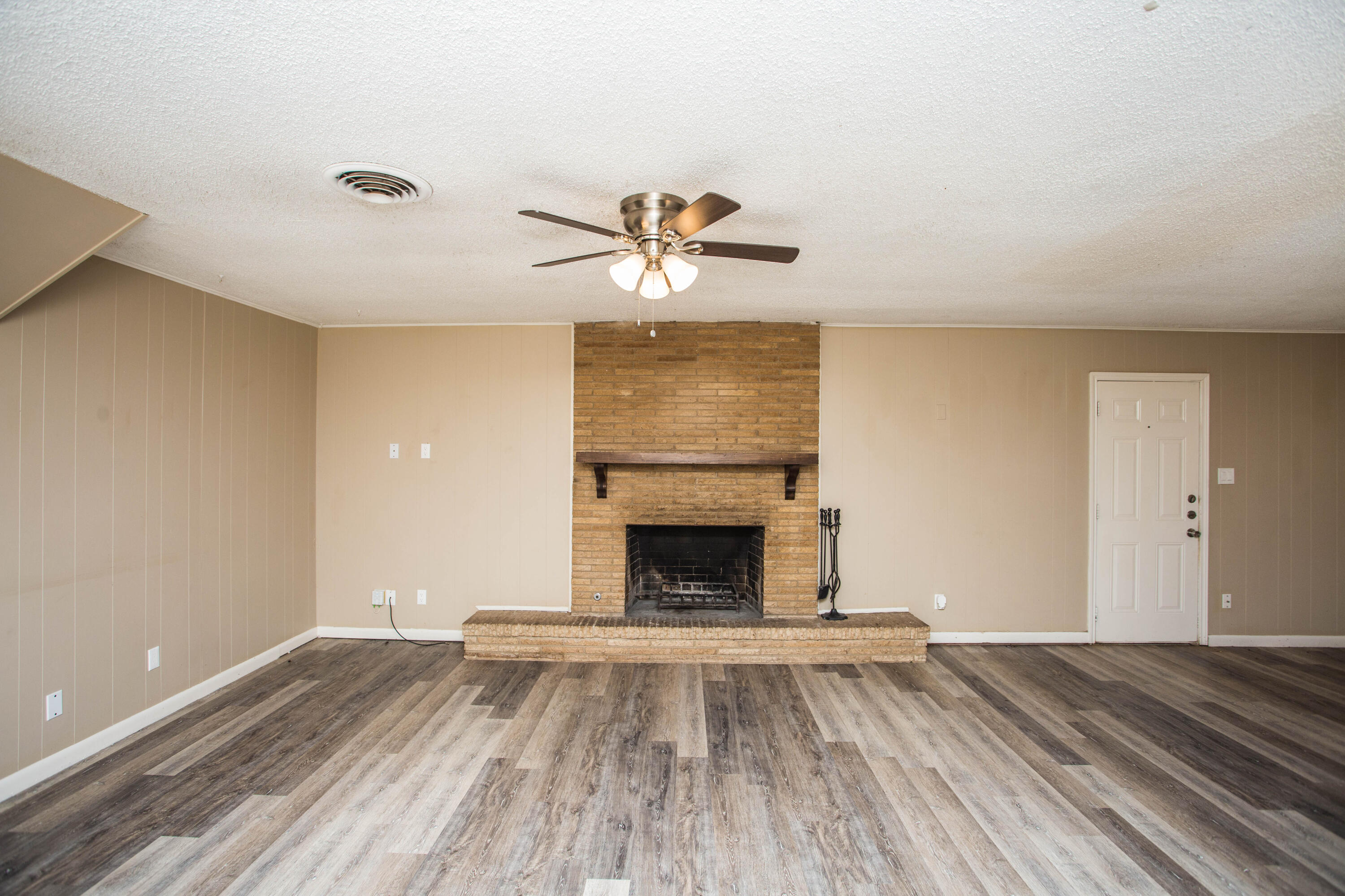 4309 42nd Street Lubbock, TX 79413 - Photo 4 of 25 wooden floor fireplace and windows in an empty room