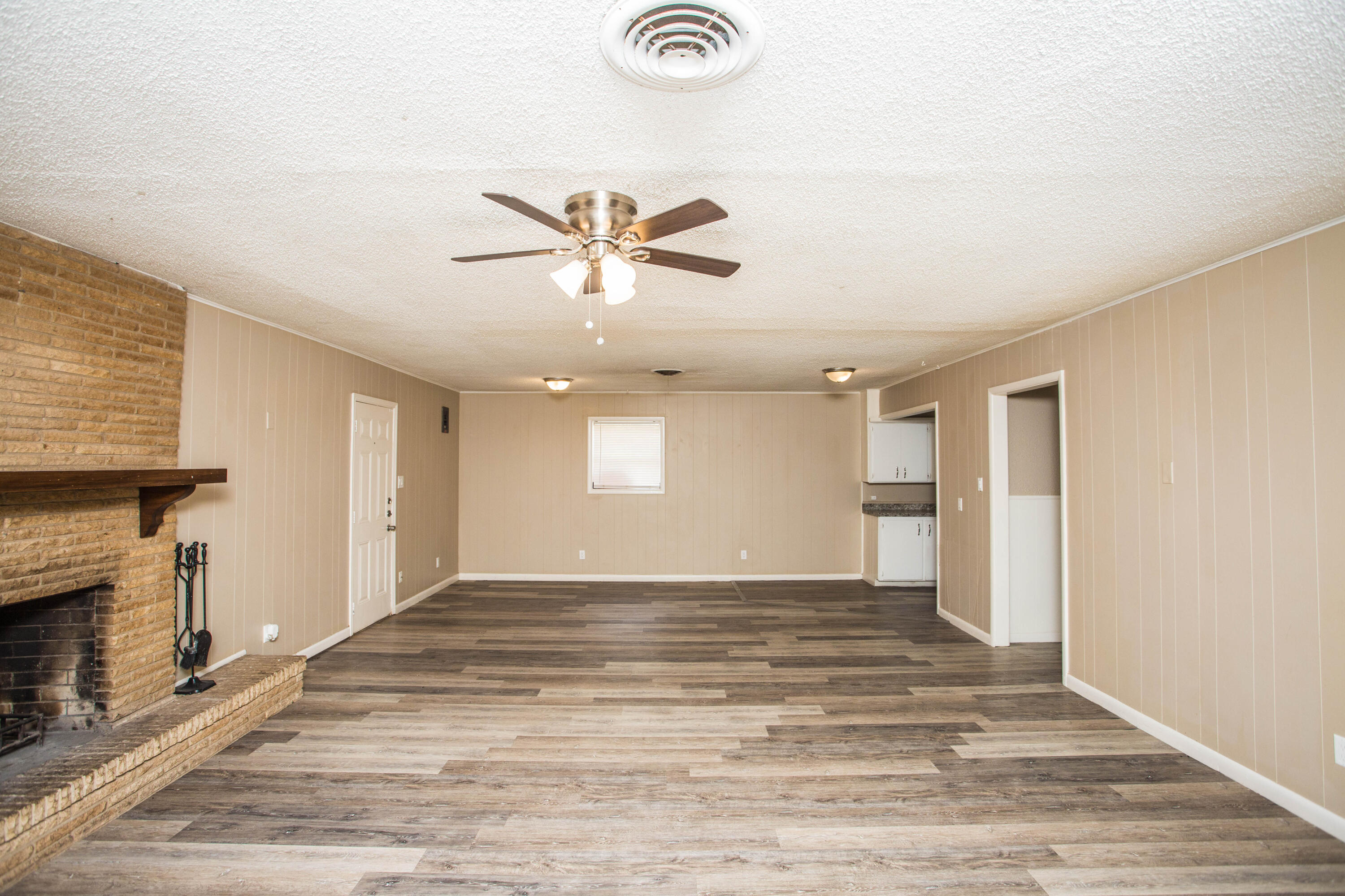 4309 42nd Street Lubbock, TX 79413 - Photo 5 of 25 an empty room with wooden floor and chandelier