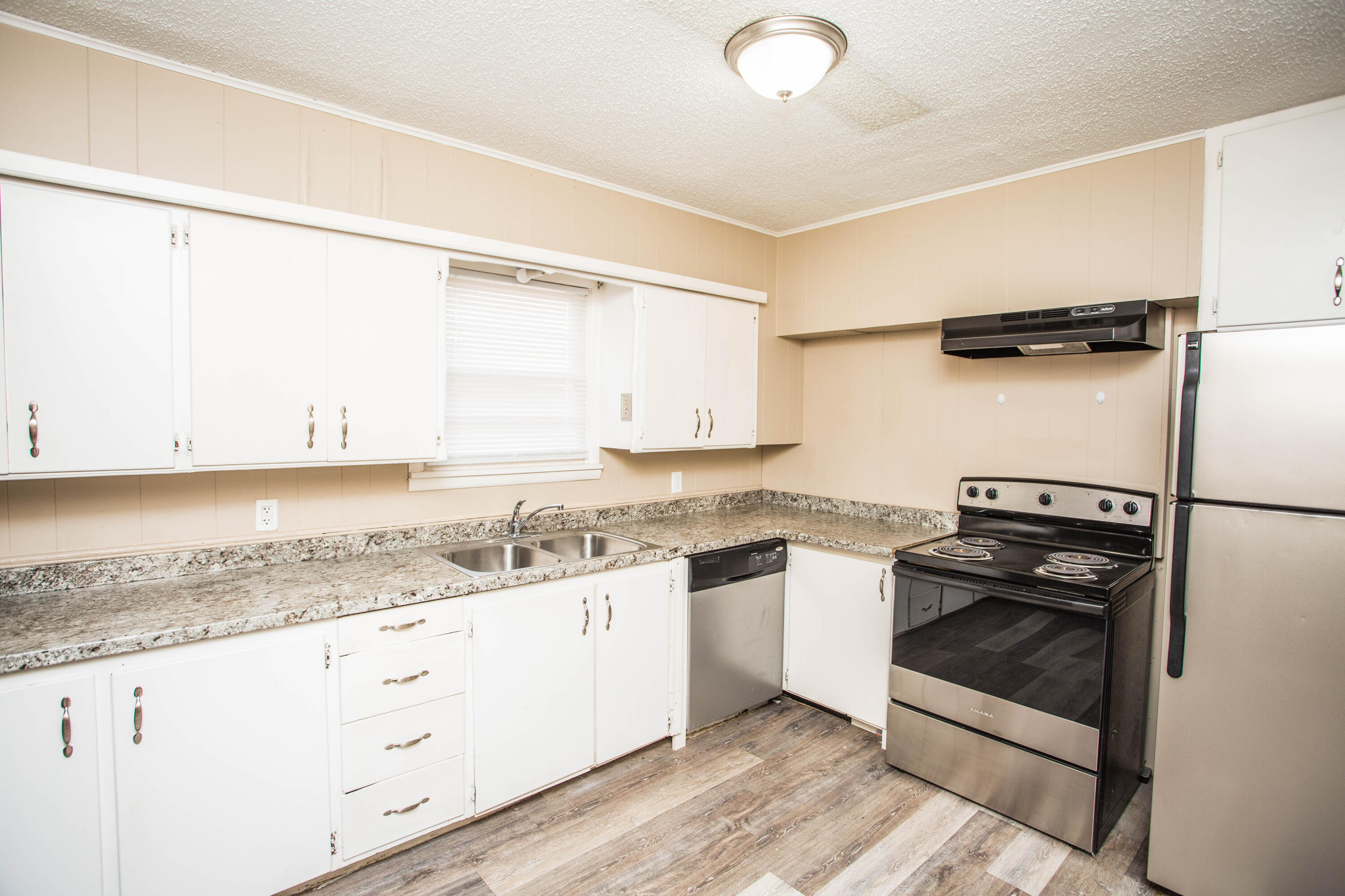 4309 42nd Street Lubbock, TX 79413 - Photo 8 of 25 a kitchen with granite countertop cabinets and steel stainless steel appliances