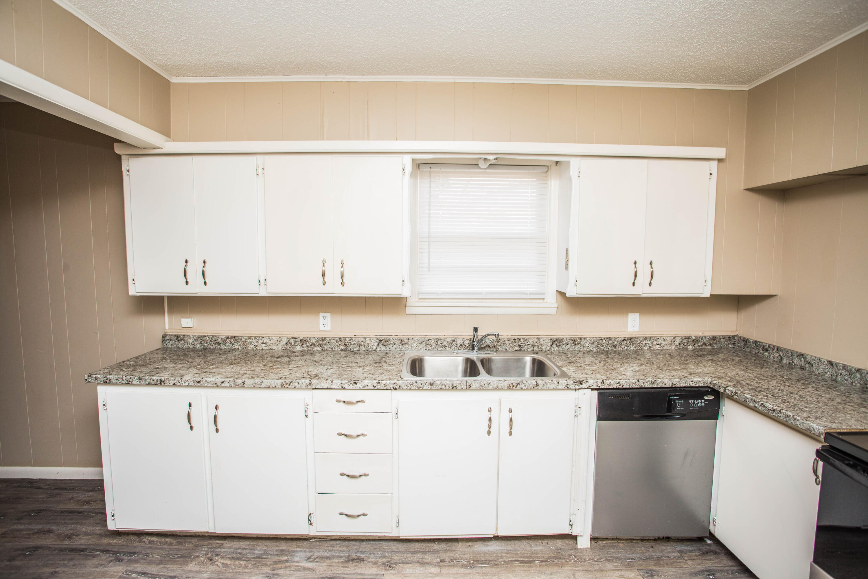 4309 42nd Street Lubbock, TX 79413 - Photo 9 of 25 a kitchen with granite countertop a sink a stove and cabinets