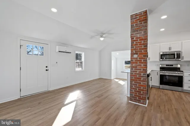 a kitchen with granite countertop a stove and a wooden floor
