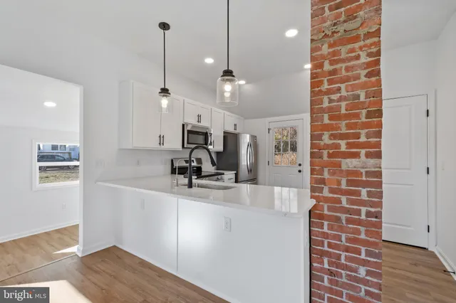 a kitchen with kitchen island a sink stainless steel appliances and a counter top space