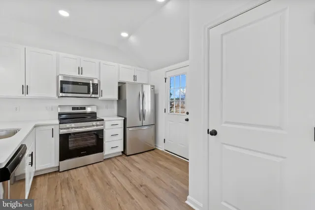a kitchen with refrigerator a microwave and stove