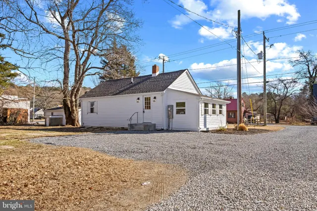 a view of a house with a yard and road