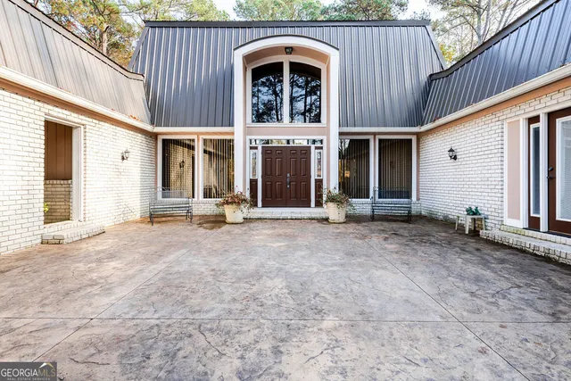 a view of a house with large windows and a small yard