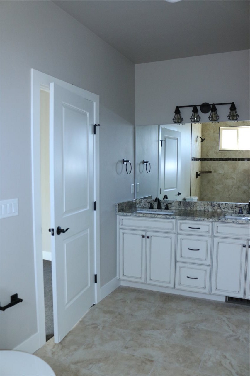 498 Tiara Rado Court Grand Junction, CO 81507 - Photo 19 of 20 a bathroom with granite countertop a sink and a mirror