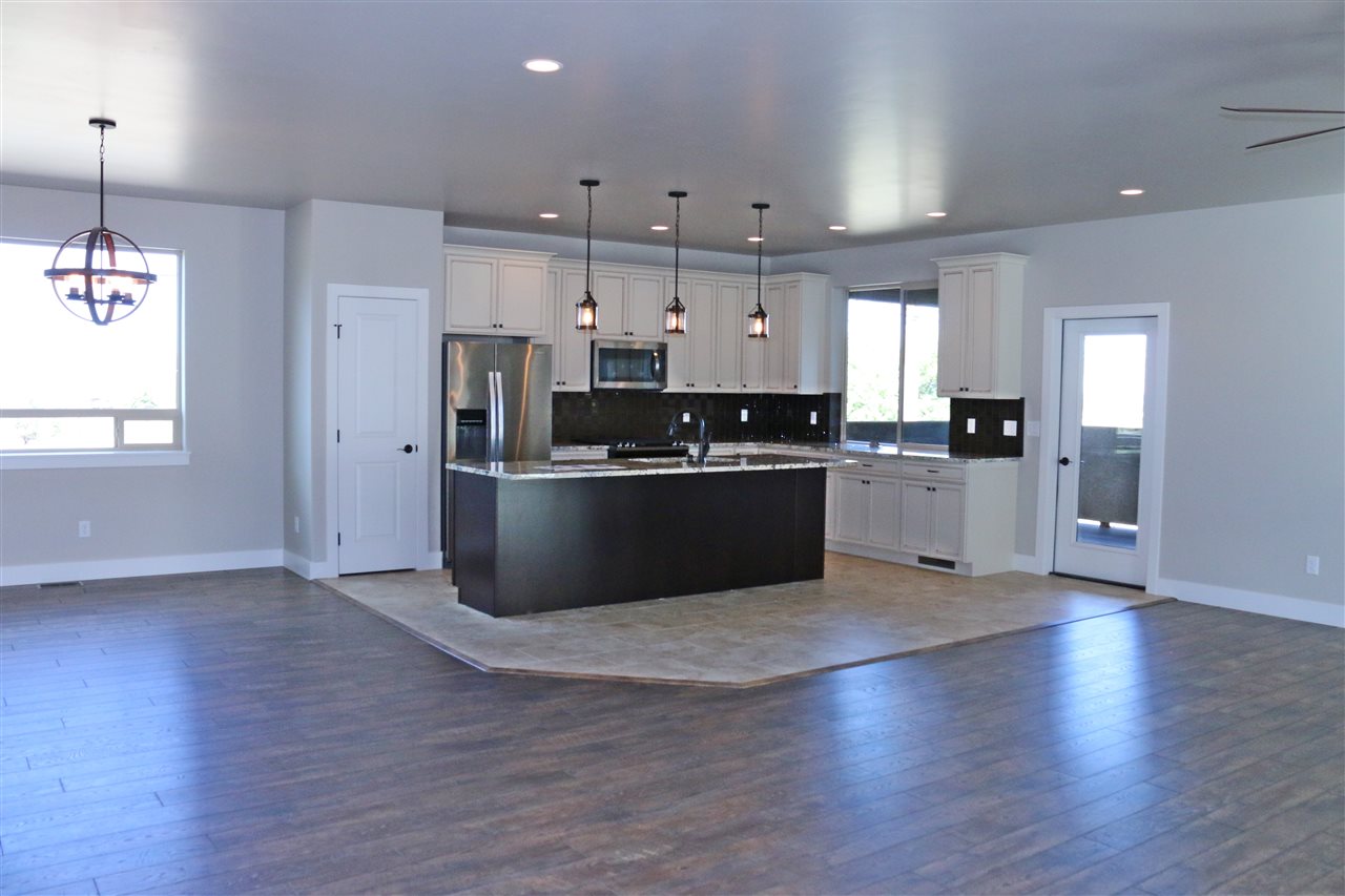 498 Tiara Rado Court Grand Junction, CO 81507 - Photo 2 of 20 an open kitchen with kitchen island wooden floors appliances and cabinets
