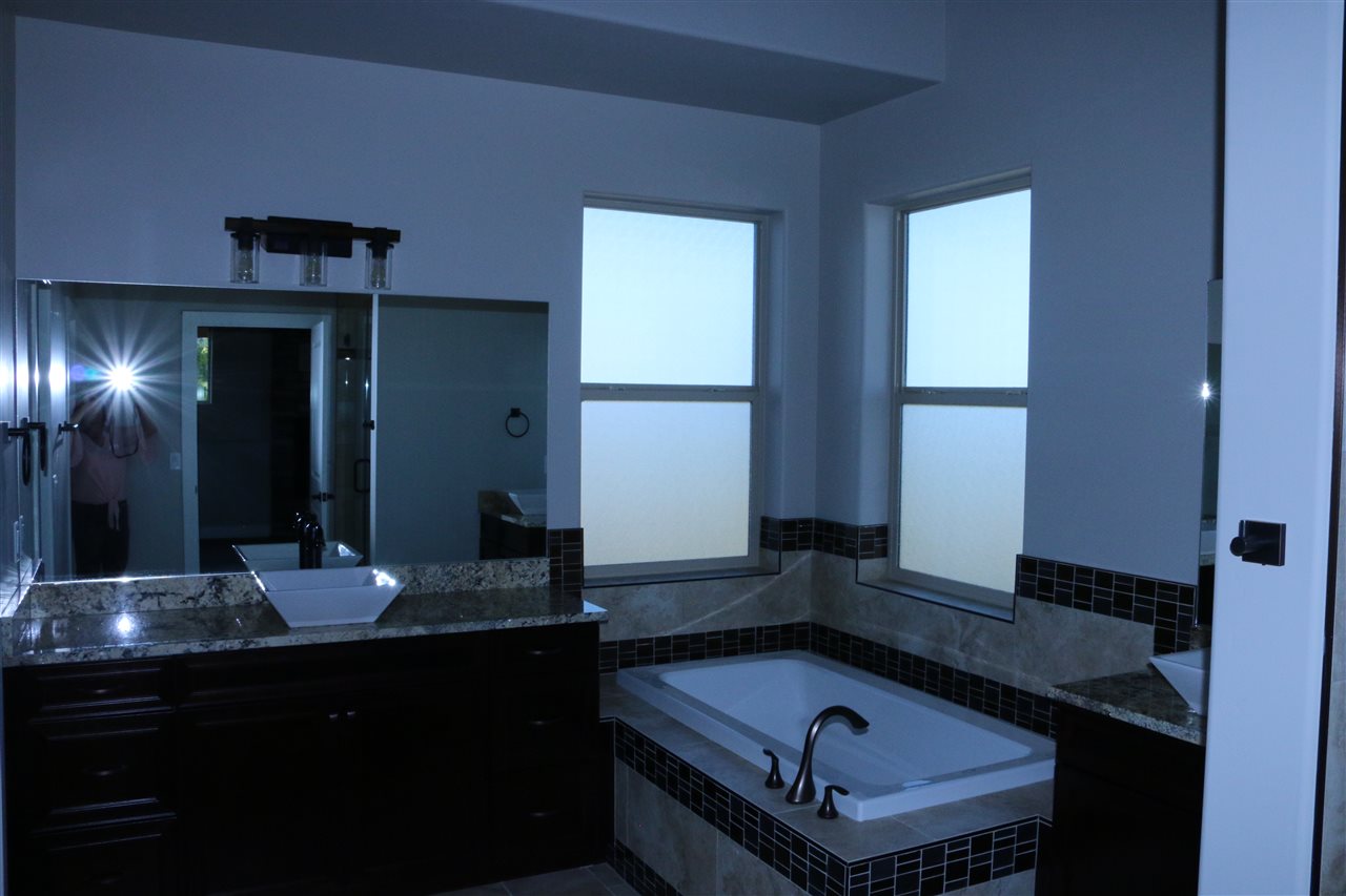 498 Tiara Rado Court Grand Junction, CO 81507 - Photo 5 of 20 a bathroom with a granite countertop sink and a mirror