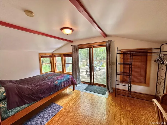 a spacious bedroom with a bed and wooden floor