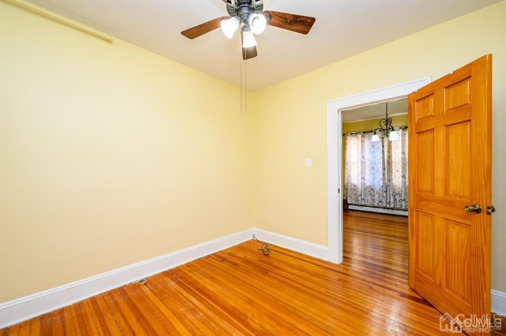 47 Marion Street Port Reading, NJ 07064 - Photo 13 of 57 a view of empty room with wooden floor and fan