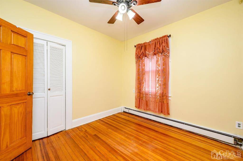 47 Marion Street Port Reading, NJ 07064 - Photo 14 of 57 a view of empty room with wooden floor and fan