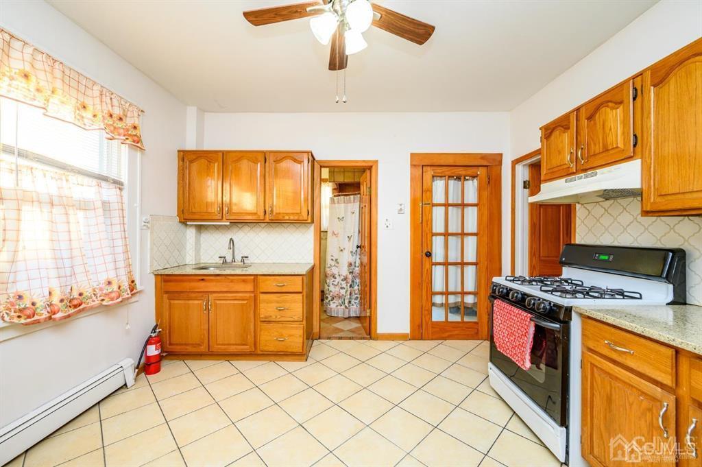 47 Marion Street Port Reading, NJ 07064 - Photo 15 of 57 a kitchen with stainless steel appliances granite countertop a stove a sink and a microwave