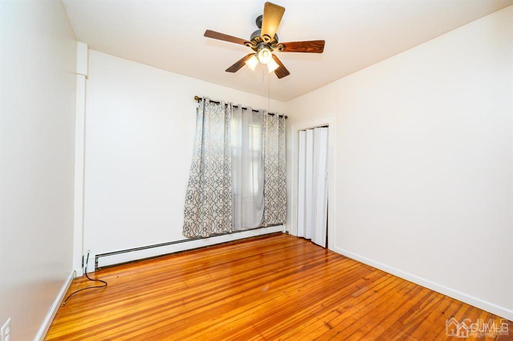 47 Marion Street Port Reading, NJ 07064 - Photo 20 of 57 a view of a room with wooden floor and a ceiling fan