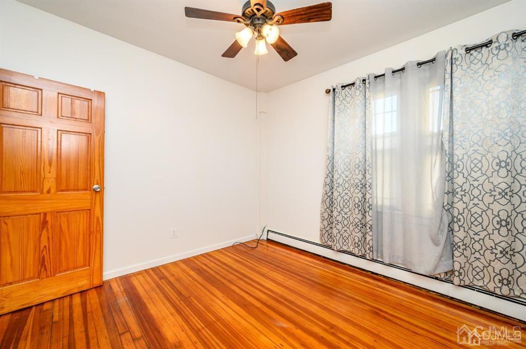 47 Marion Street Port Reading, NJ 07064 - Photo 22 of 57 a view of empty room with wooden floor and fan