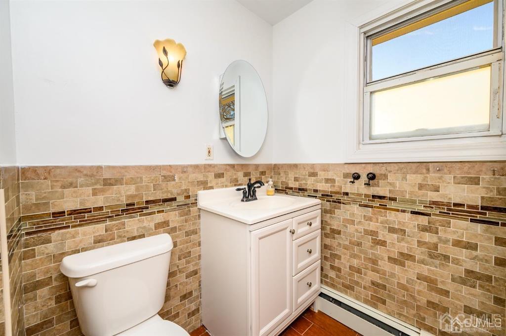 47 Marion Street Port Reading, NJ 07064 - Photo 39 of 57 a bathroom with a sink a toilet and a mirror
