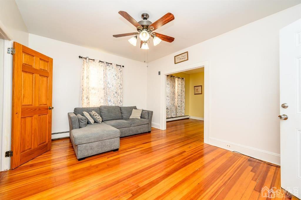47 Marion Street Port Reading, NJ 07064 - Photo 4 of 57 a living room with couches and potted plants with wooden floor