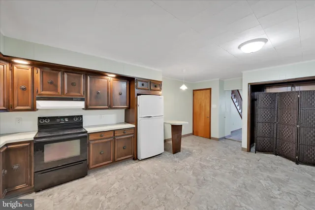 a kitchen with stainless steel appliances granite countertop a refrigerator and a stove top oven