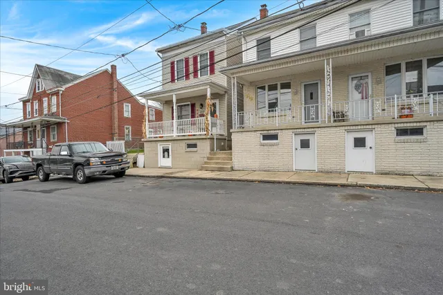 a view of a street that has couple of cars parked in front of it