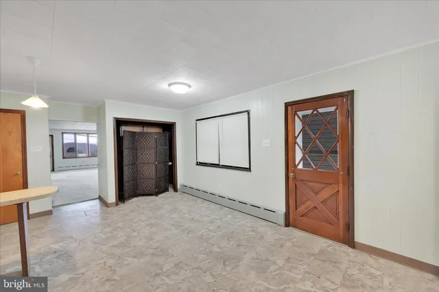 an empty room with closet and windows