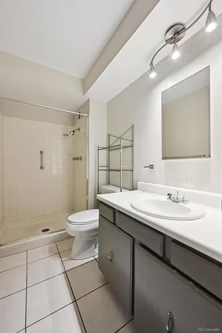 a bathroom with a granite countertop sink a toilet and a mirror