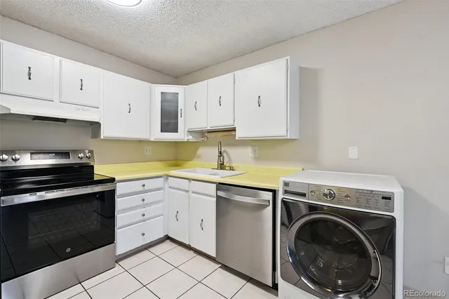 a kitchen with cabinets stainless steel appliances and a sink