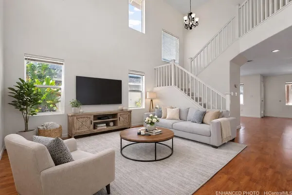 a living room with furniture a flat screen tv and a potted plant
