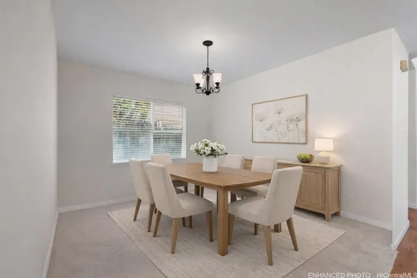 a dining room with furniture a chandelier and window