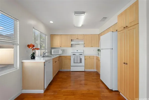 a kitchen with white cabinets and white appliances
