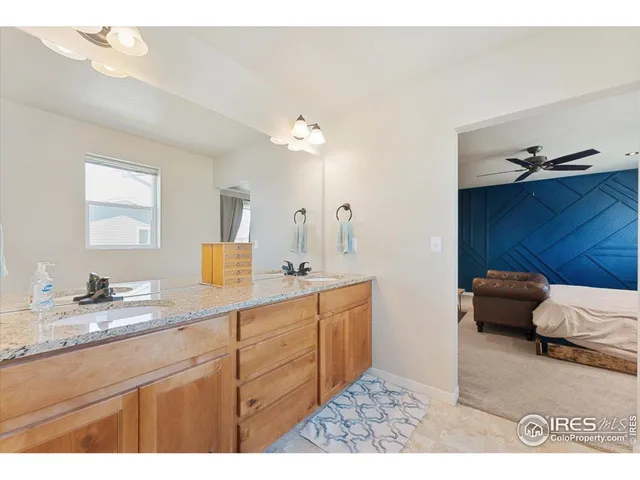 a en suite bathroom with a granite countertop sink and a mirror