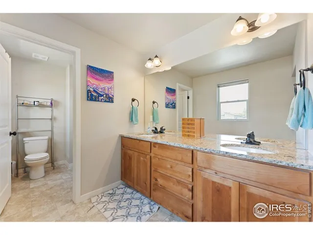 a bathroom with a granite countertop sink a toilet and a mirror