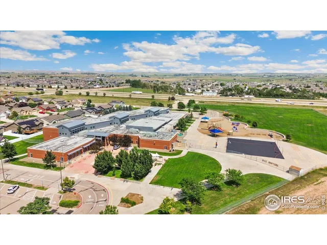 an aerial view of a city with lots of residential buildings ocean and mountain view in back