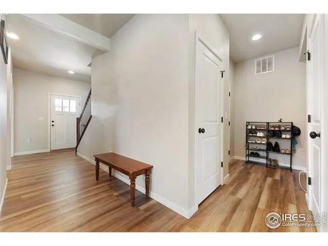 a view of a hallway with wooden floor and furniture