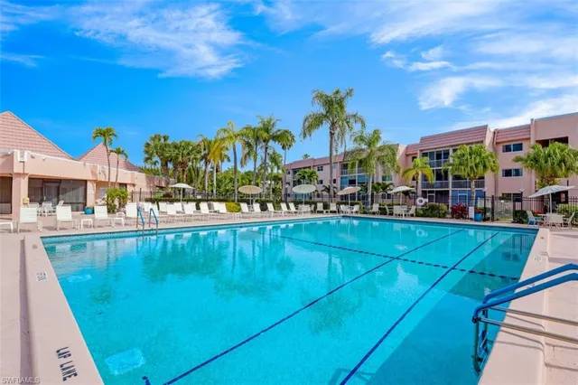 a front view of a building with lot of cars parked