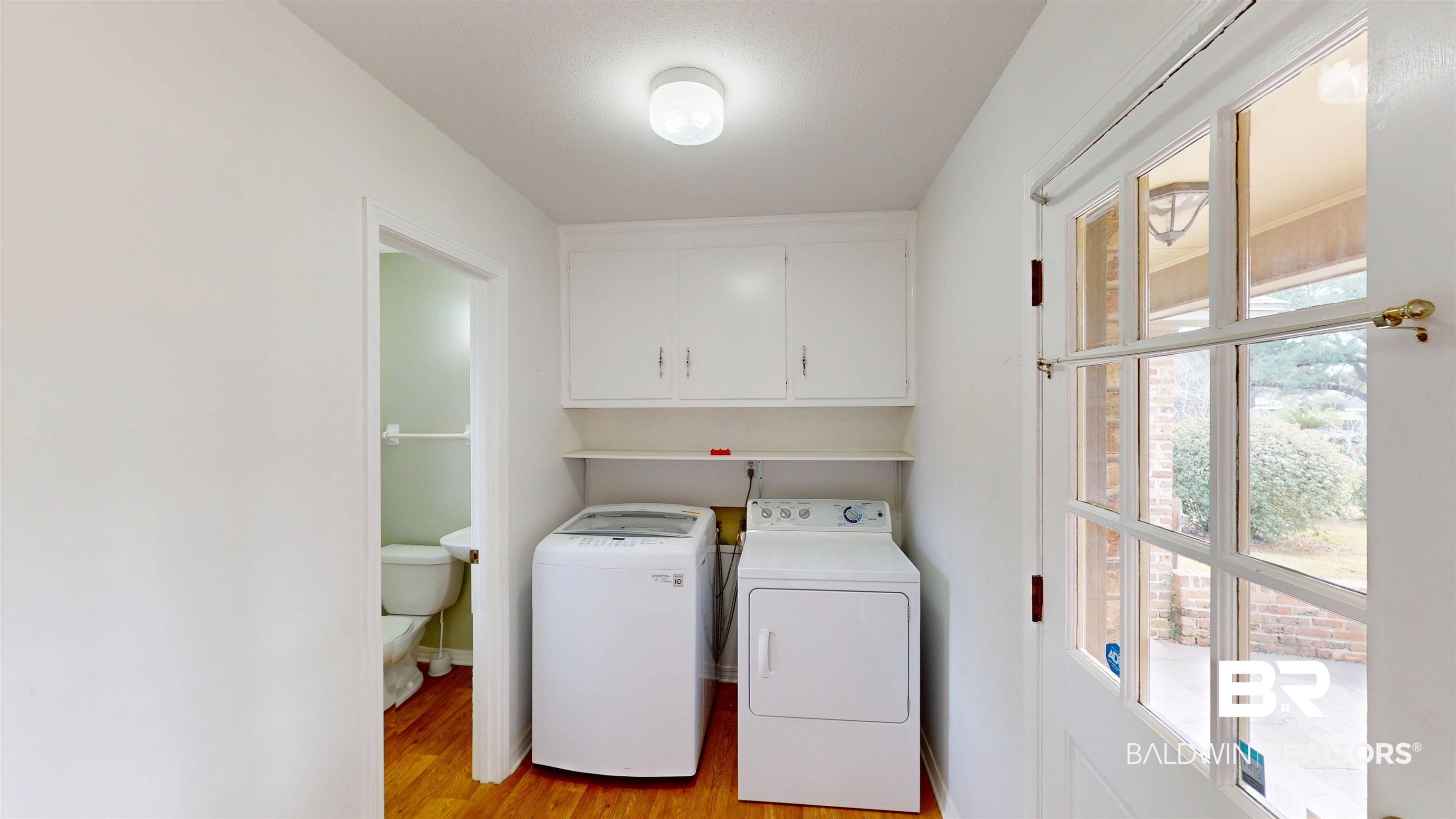 609 Burlington Court Mobile, AL 36608 - Photo 8 of 19 Laundry room with light wood-style floors, cabinet space, and separate washer and dryer
