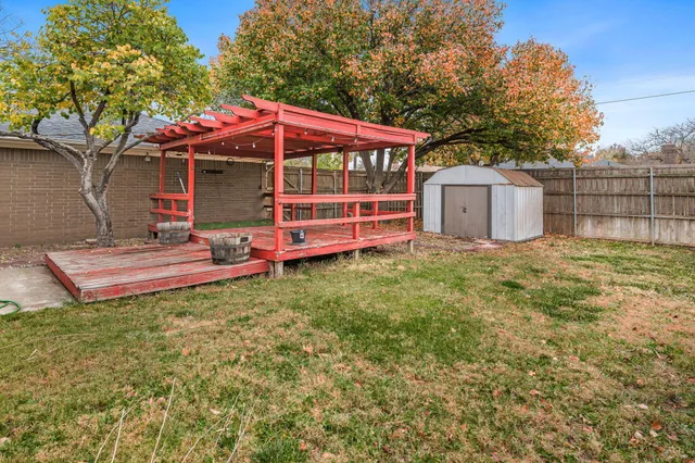 a view of a house with a yard and wooden fence