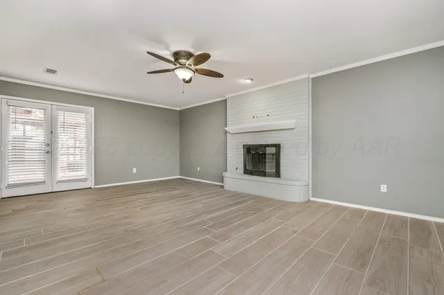 a view of an empty room with a fireplace and a window