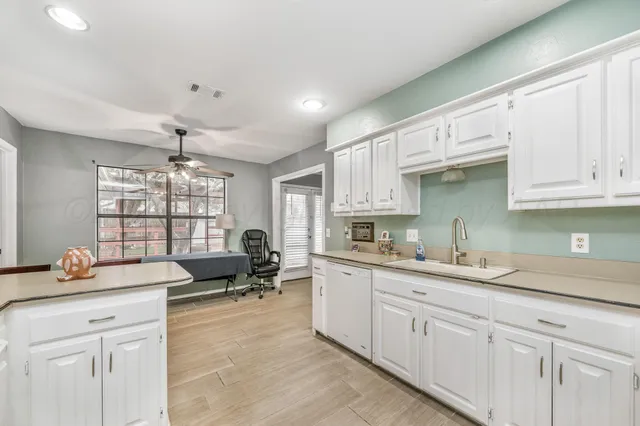 a kitchen with granite countertop a sink and cabinets