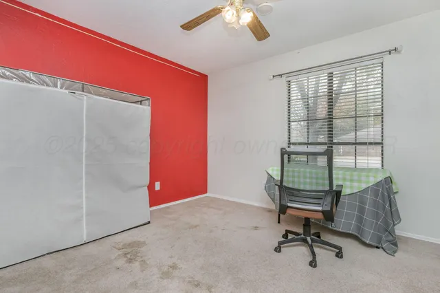a view of a workspace with furniture and a window