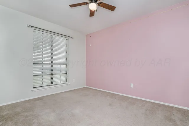 an empty room with chandelier fan