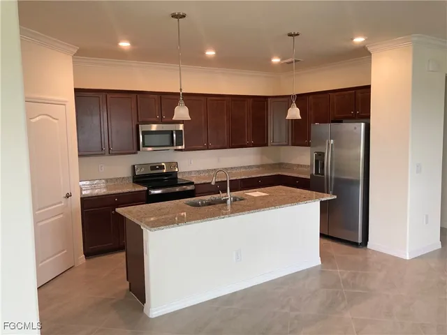 a kitchen with stainless steel appliances granite countertop a sink a stove and a refrigerator