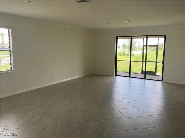 an empty room with floor to ceiling window and an outdoor view